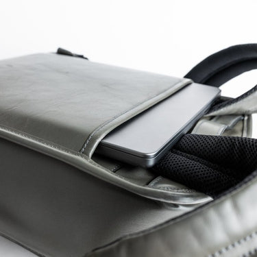 Gray leather backpack laptop sleeve view.